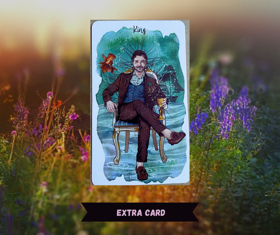 Background of sunlit flowers with King of Cups tarot card in front of it. Card depicts a man in business casual clothing sitting on a chair with a cup in his hand at the bottom of the sea with fish swimming nearby and a shipwreck in the background. Words "Extra Card" in pink over a black ribbon. 